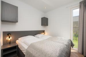 a bedroom with a large bed and a window at Vakantiepark Buitenplaats Holten in Rijssen +19 photos