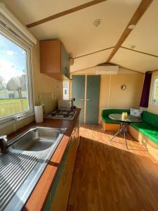 a kitchen with a sink and a large window at Ruben Bungalow in Bourbourg