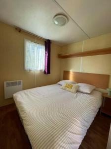 a bedroom with a large white bed with a pillow at Ruben Bungalow in Bourbourg