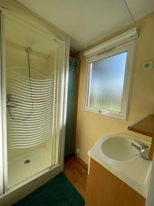 a bathroom with a shower and a sink and a mirror at Ruben Bungalow in Bourbourg