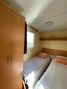 a small bedroom with two beds and a window at Ruben Bungalow in Bourbourg