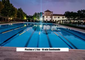 a swimming pool at night with a building in the background at La Casa del Conde - Un alojamiento único en Écija in Écija