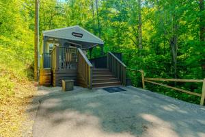 a small building with a staircase in the woods at Serenity at the Smokies in Sevierville