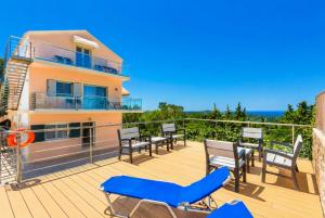 a balcony with chairs and tables and a building at Villa Stephania in Gaios