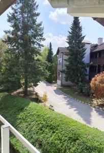 a view of a yard with two trees and a building at Solar Club Apartman Sopron in Sopron