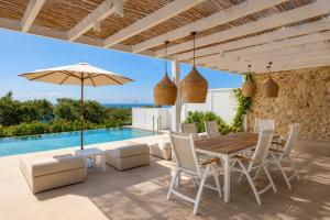 a patio with a table and chairs and a pool at Villa Pollux in Gennadi