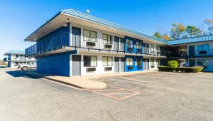 a blue and white building with a parking lot at Xpress Inn & Extended Stays in Marshall