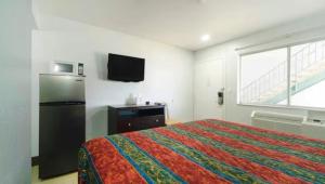 a bedroom with a bed and a refrigerator and a window at Xpress Inn & Extended Stays in Marshall