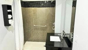a bathroom with a shower with a black counter at Xpress Inn & Extended Stays in Marshall +24 photos