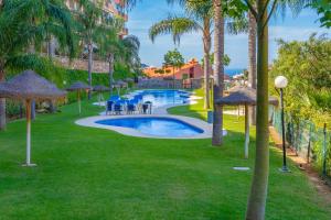 a pool with chairs and umbrellas at a resort at Piso La Alondra in Fuengirola
