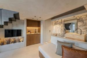 a living room with a bed and a tv and a staircase at Agnadema Apartments in Firostefani