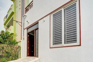 a building with a window with blinds on it at Kayilai Residency in Pīlamedu
