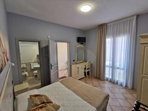 a bedroom with a bed and a sink and a mirror at Il Giardino del Sol in San Vito lo Capo