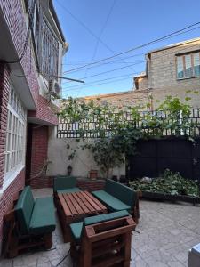 a patio with two benches and a table and chairs at Ezo in Tbilisi City