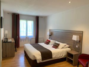 a bedroom with a large bed and a red chair at Logis Hotel Restaurant de l'Abbaye in Ferrières +40 photos