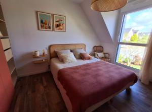 a bedroom with a bed and a large window at Les Ganivelles in Belz