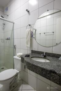 a bathroom with a toilet and a sink and a mirror at Rede Andrade Royal in Itabuna +17 photos