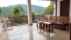 a balcony with a bench and a view of the mountains at The Blooming Tulip in Shergaon