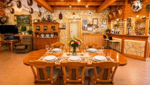 a dining room with a wooden table and chairs at Szabó Tanya Nyim in Nyim
