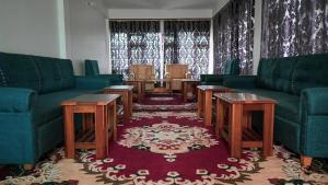 a living room with couches and a table and chairs at The Blooming Tulip in Shergaon