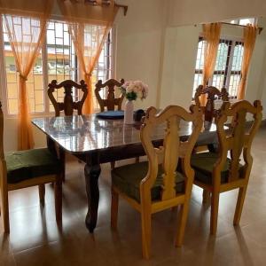 a dining room with a wooden table and chairs at The Blooming Tulip in Shergaon