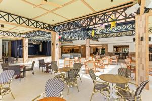 a dining area with tables and chairs and a cafeteria at Aquasol Aparthotel in Palmanova
