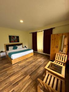 a bedroom with a bed and a wooden floor at Crest Manali River View in Manāli