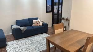 a living room with a blue couch and a table at Apartment 22 - Jundiaí in Jundiaí