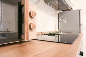 a kitchen with a sink and a stainless steel refrigerator at La casetta in corte in Cormano