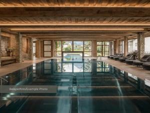 a swimming pool in a house with glass floors at VAYA Post Montafon - Neueröffnung Dezember 2026 in Gaschurn