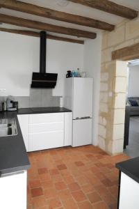 a kitchen with white cabinets and a white refrigerator at Le Petit Musée in Loches