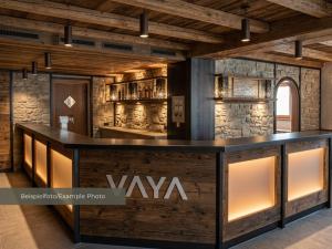 a bar in a room with a stone wall at VAYA Post Montafon - Neueröffnung Dezember 2026 in Gaschurn
