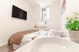 a white room with a bed and a sink at La casetta in corte in Cormano
