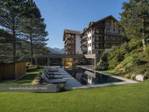 a building with a bridge over a body of water at VAYA Post Montafon - Neueröffnung Dezember 2026 in Gaschurn