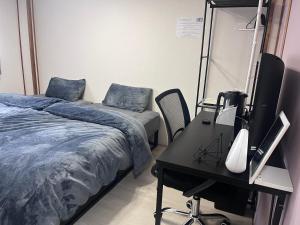 a bedroom with a bed and a desk with a television at Cafe Sharehouse Kokoro Nest Kyoto in Kyoto +26 photos