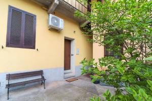 a bench sitting in front of a yellow building at La casetta in corte in Cormano
