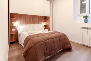 a bedroom with a large bed with a brown tufted blanket at La casetta in corte in Cormano