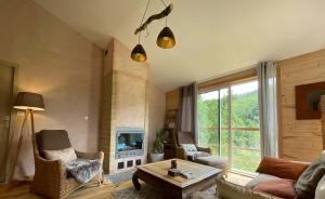 a living room with a couch and chairs and a fireplace at Source Nature in Le Mas-dʼAzil