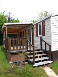 a mobile home with a porch and a deck at Séjour à litteau in Litteau +2 photos