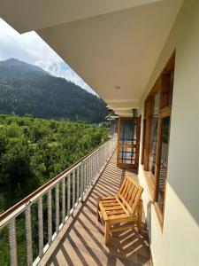 a balcony with two chairs on a house at Crest Manali River View in Manāli