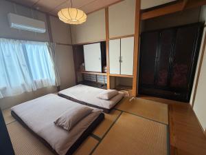 a room with two beds in a room with a window at 民泊ごとう in Kitakami