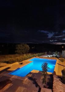 a blue swimming pool at night at Kamena kuća Goranci in Mostar +30 photos