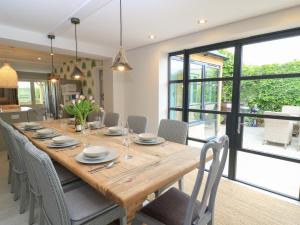 a dining room with a long wooden table and chairs at Fairview Cottage in Burford