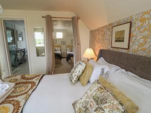 a bedroom with a large bed with pillows at Fairview Cottage in Burford
