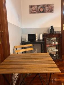 a kitchen with a wooden table and a microwave at Alojamento Local Tamega in Amarante