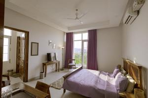 a bedroom with a bed and a large window at IT City Luxe Homestay-Secure & Comfortable Stay in Mohali in Mohali
