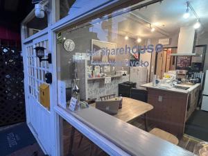 a restaurant with a counter and a table in a window at Cafe Sharehouse Kokoro Nest Kyoto in Kyoto