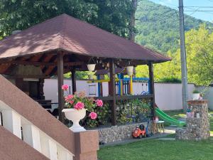 a wooden gazebo with a playground in a yard at Bukuljska svežina 1 in Arandelovac