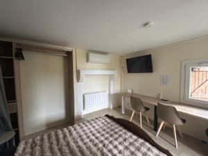 a bedroom with a bed and a tv on the wall at Studio cosy 71 in Saint-Vallier