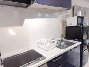 a small kitchen with a sink and a refrigerator at Hachi Kamakura KOIWA in Tokyo